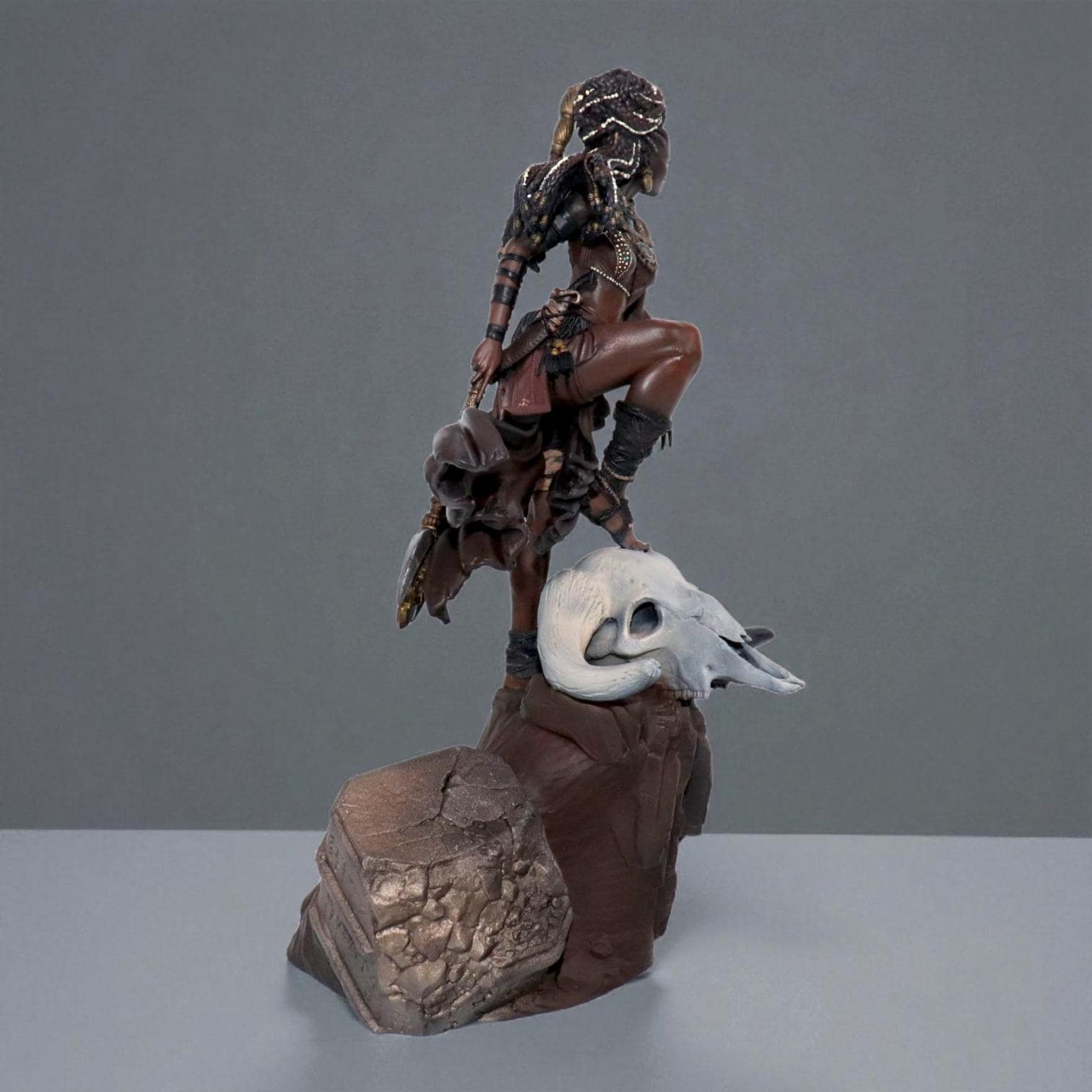 Elzebe, the Warrior Queen, stands atop a rocky skull, exuding strength and regality. Clad in intricate armor, her braided hair flows as she surveys the battlefield. A fierce leader, she embodies resilience and power, a true queen of war and legend.