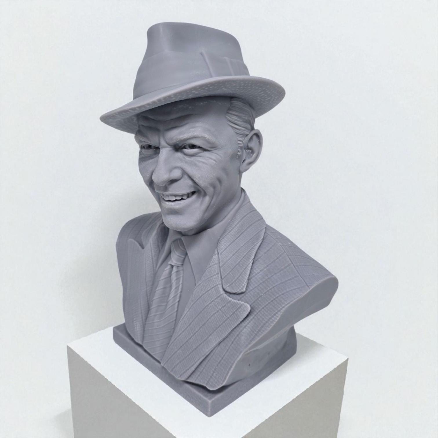 3D-printed bust of Frank Sinatra wearing a classic fedora and suit with a wide smile, showcasing detailed facial features and textured clothing. A tribute piece perfect for fans, collectors, or display décor.