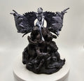 Sculpture of an angel with wide wings sitting atop a mound of intertwined figures representing darkness, depicted in intricate detail.