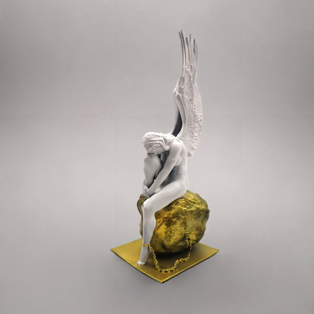 Statue of a chained angel seated on a textured pedestal, with detailed wings and a contemplative pose.