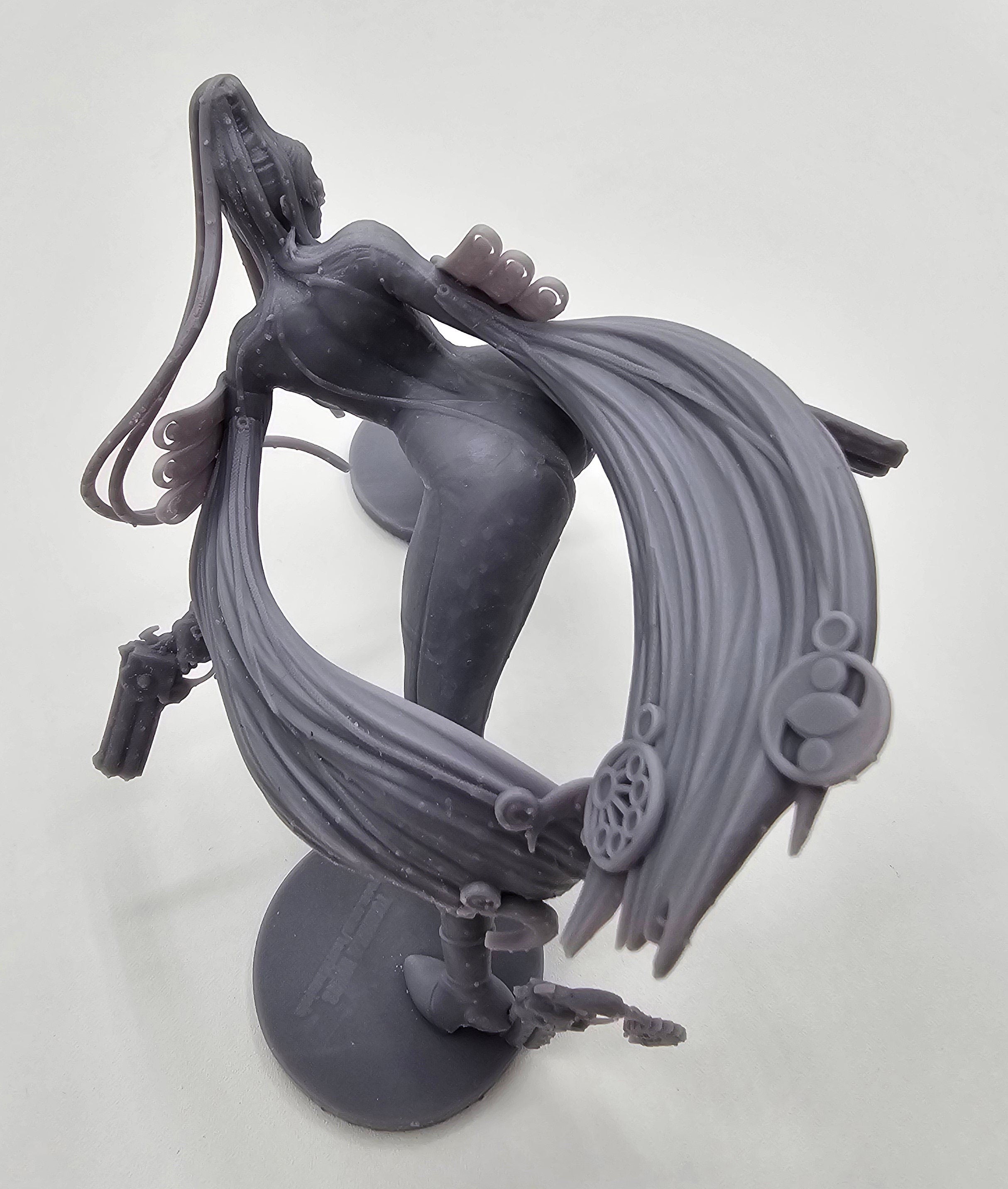 A highly detailed Bayonetta statuette showcasing her dynamic pose with dual guns and flowing hair, capturing her elegance, power, and iconic style from the video game series.