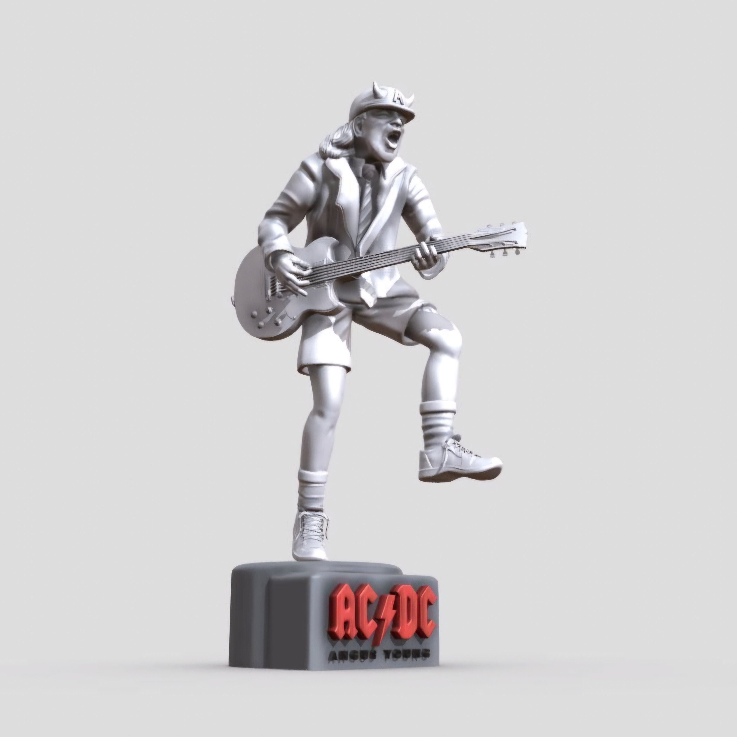 Statue of Angus Young from AC DC, depicted in a dynamic pose with his iconic guitar and schoolboy uniform, standing on a base engraved with the band&#39;s logo.