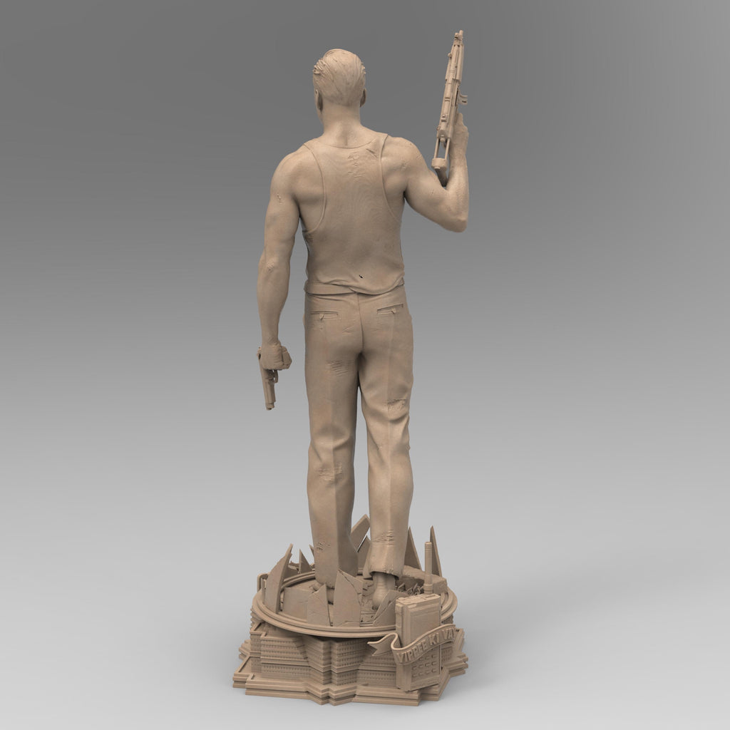 A detailed 3D-printed statue of McLane of Mayhem, posed dynamically with a machine gun and pistol, standing atop a sculpted base featuring shattered glass and city elements. Perfect for collectors and action movie fans.