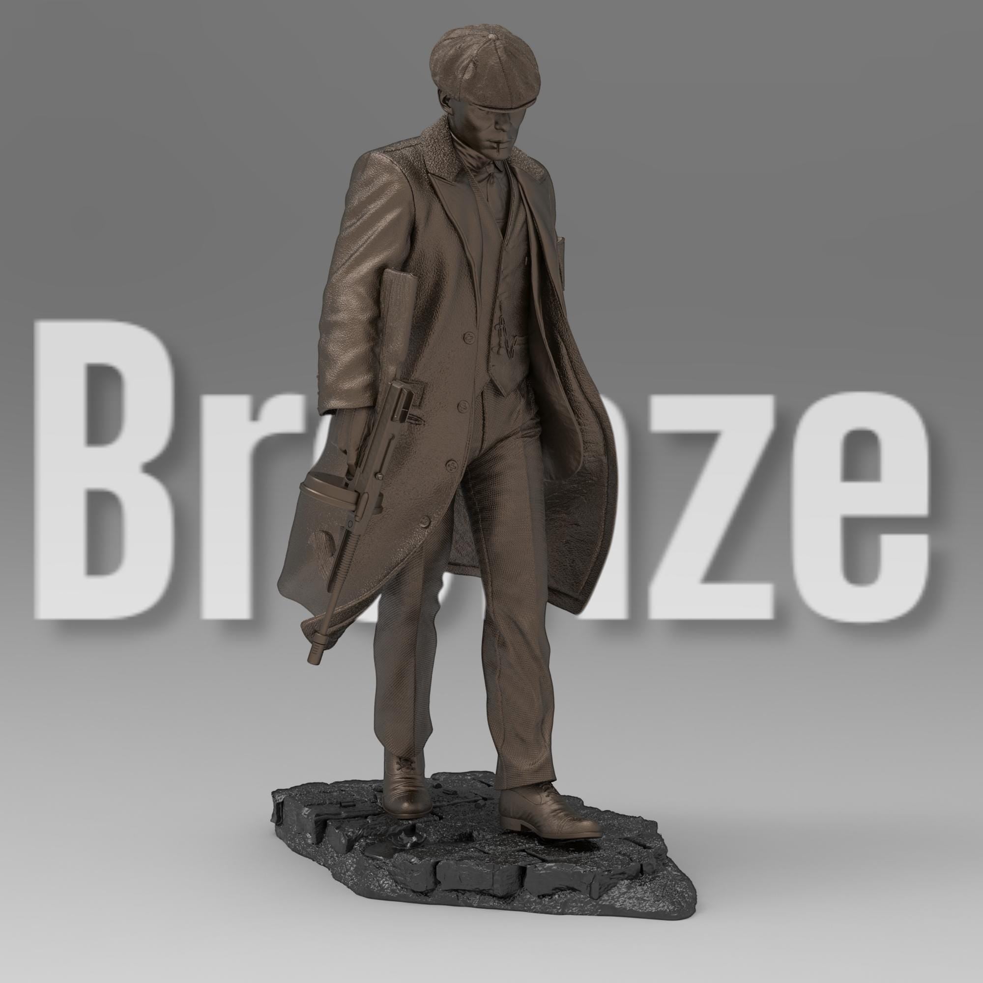 A bronze-colored figurine depicts a man in a long coat and newsboy cap, holding a submachine gun. He stands on a textured, dark gray base, styled as a cobblestone street. The figurine is detailed, capturing the texture of the fabric and the weapon.  The overall style suggests a gangster or 1920s era figure.
