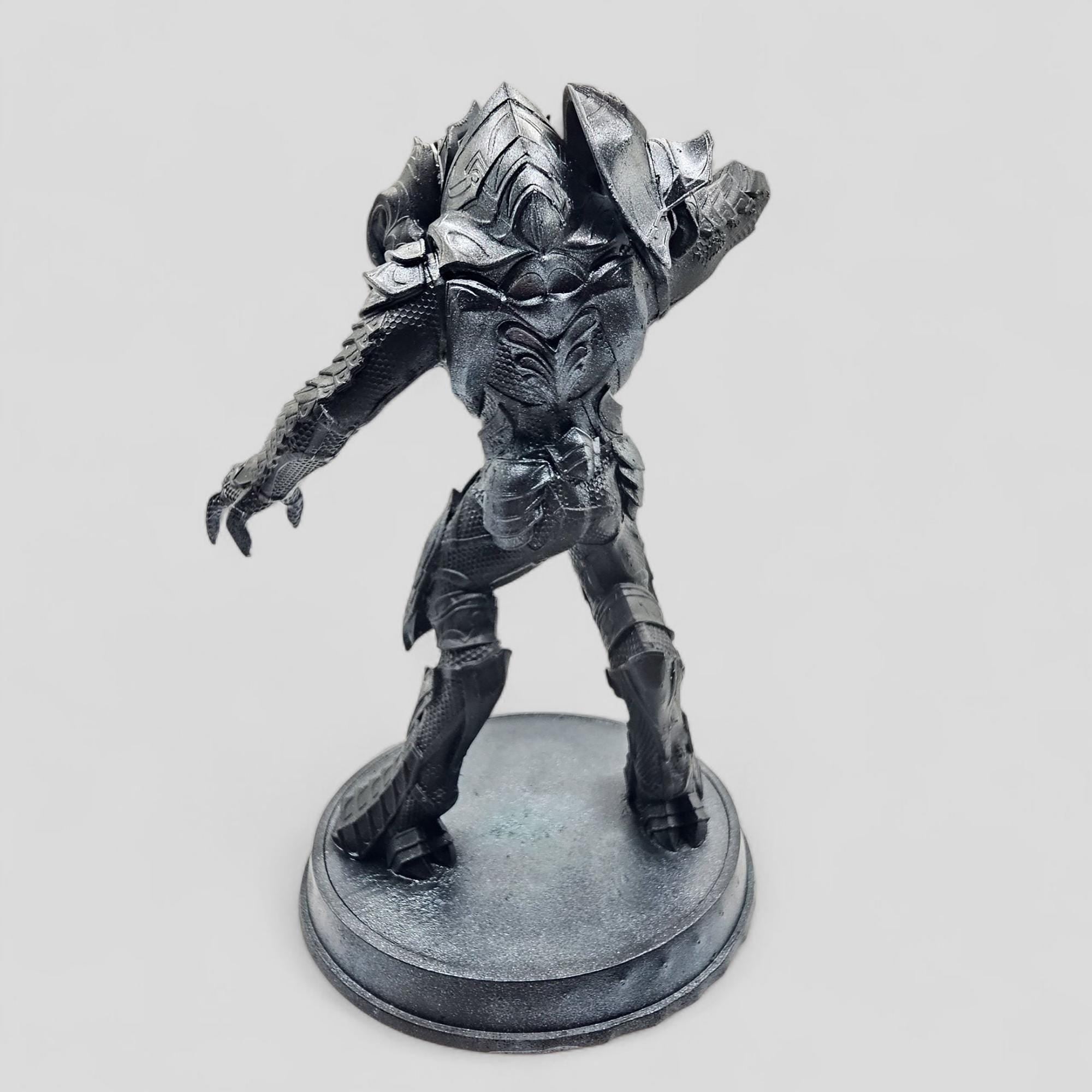 Statue of Arbiter, featuring detailed armor and a dynamic pose on a round base.