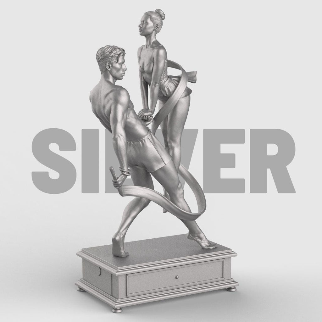 3D-printed figurine of a male and female dancer entwined with flowing ribbons, symbolizing harmony and balance. The male figure stands firm holding the ribbon while the female dancer rises gracefully on pointe, their hands interlocked. The dynamic ribbons encircle them, emphasizing movement and unity. Mounted on a rectangular decorative base.