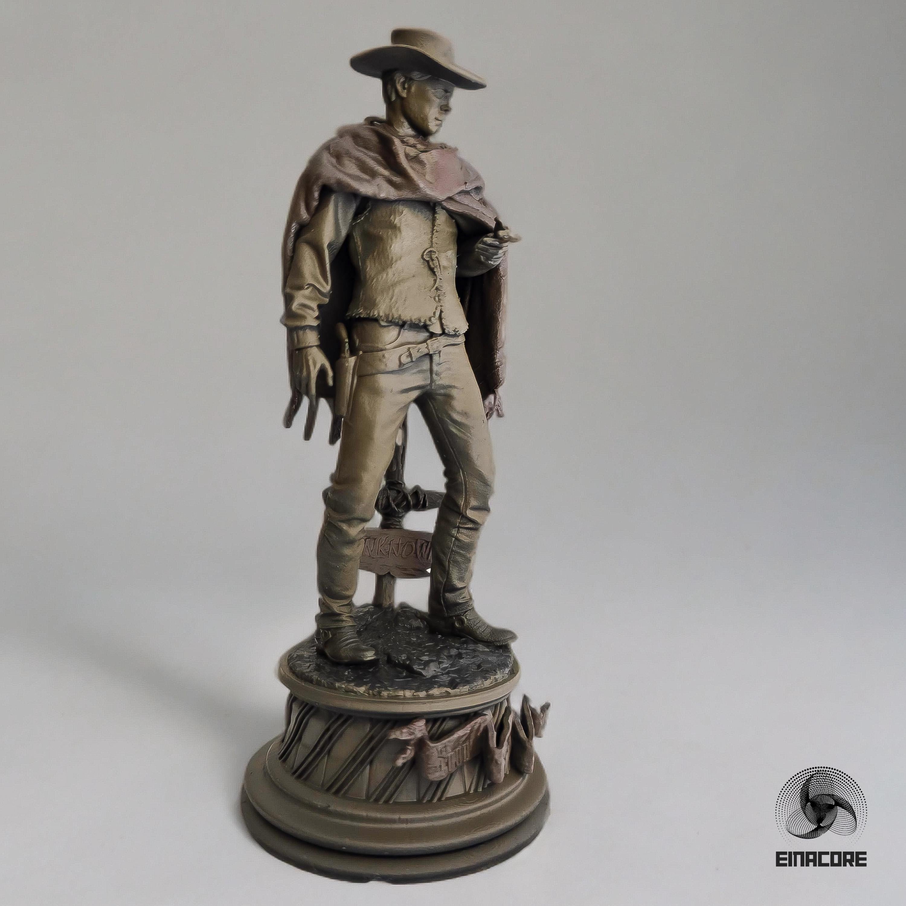 Statue of Clint Eastwood in a cowboy outfit, featuring a poncho, hat, and revolver, standing on a detailed round base with decorative elements.