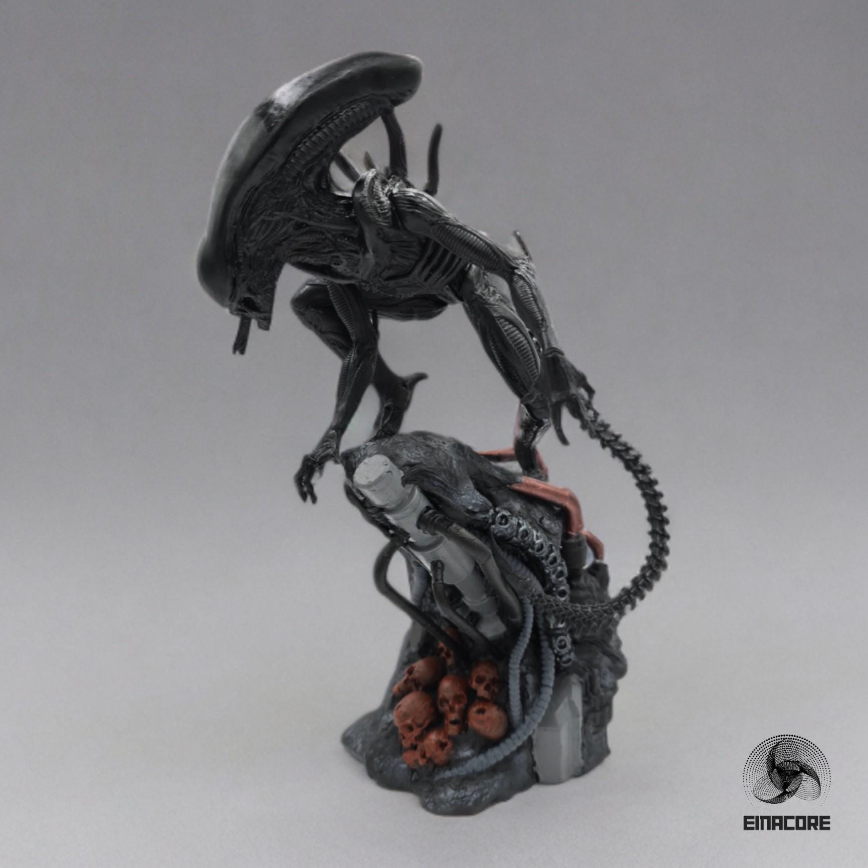 Alien Exomorph Statuette featuring intricate biomechanical details, posed on a rocky base with skulls and metallic pipes, showcasing the creature’s iconic tail and menacing posture.