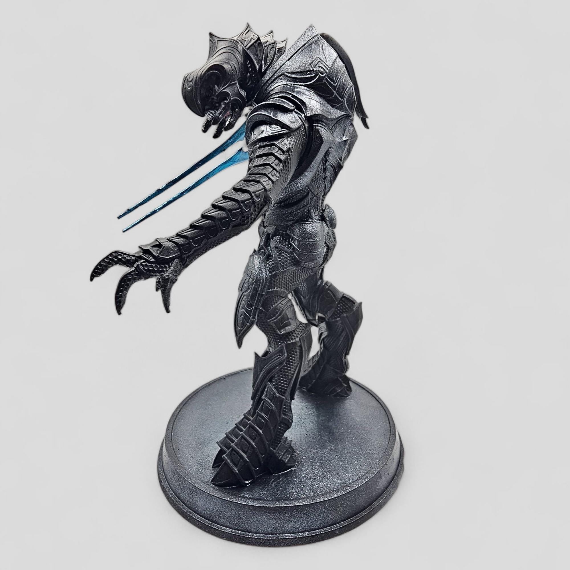 Statue of Arbiter, featuring detailed armor and a dynamic pose on a round base.
