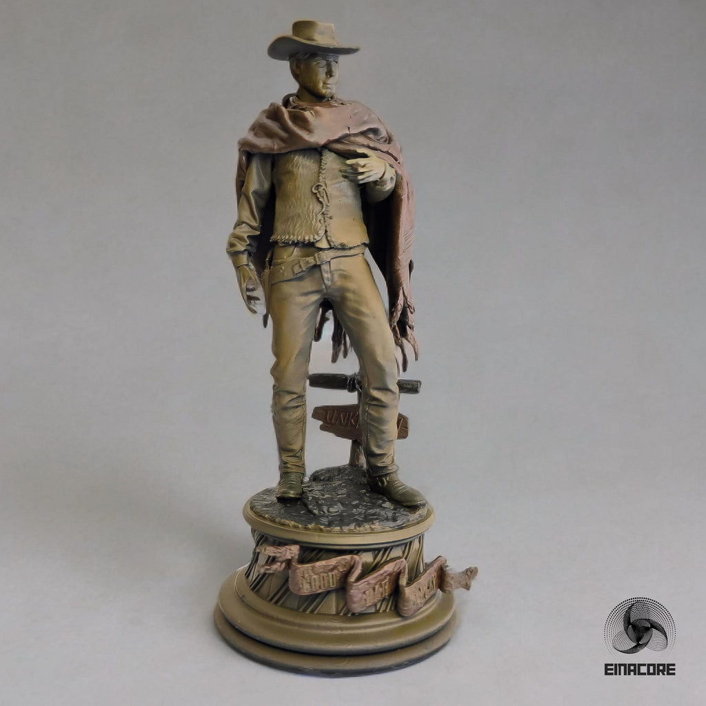 Statue of Clint Eastwood in a cowboy outfit, featuring a poncho, hat, and revolver, standing on a detailed round base with decorative elements.