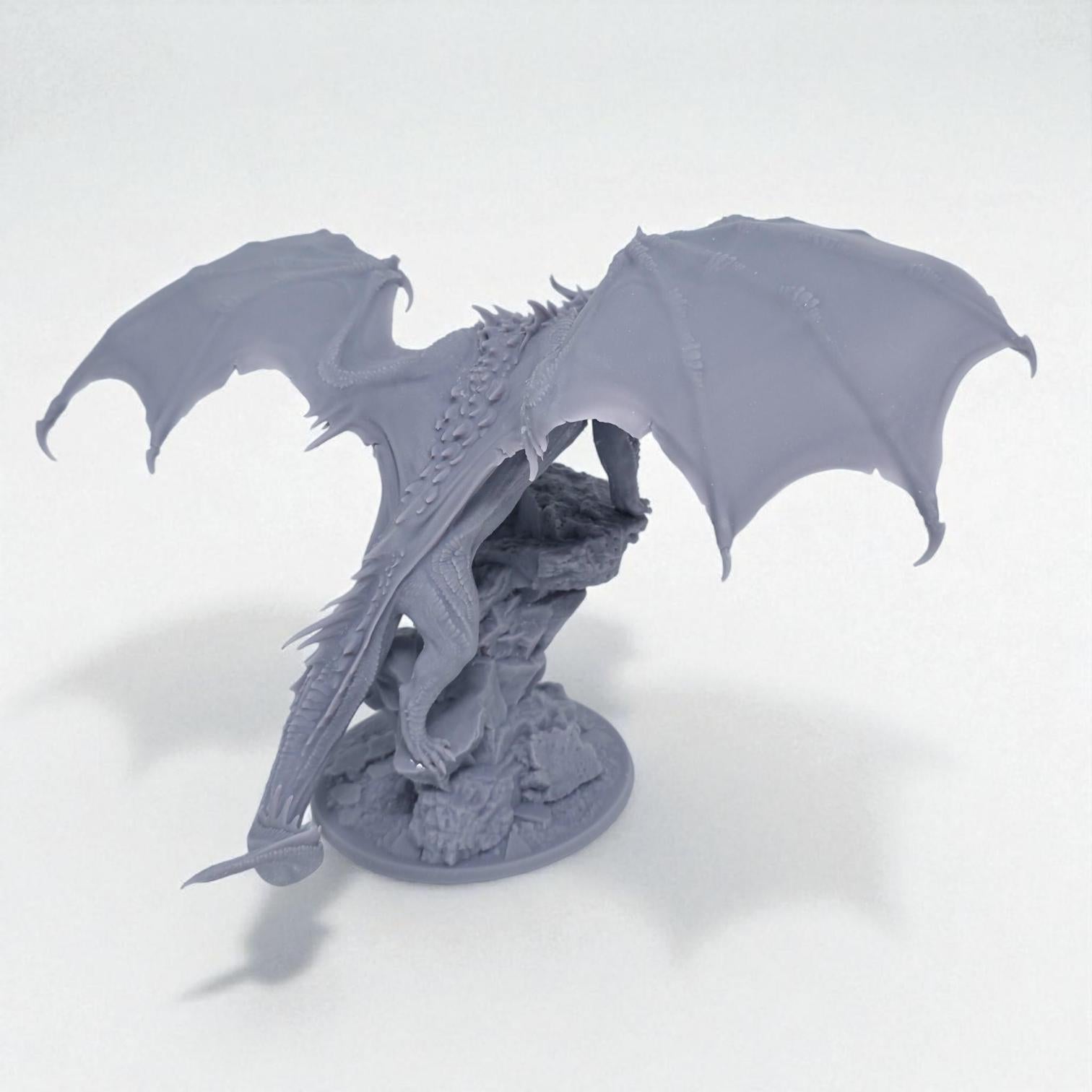 A fearsome Chromatic Red Dragon perches atop a rocky outcrop, wings spread wide and mouth open in a menacing roar. Its scales are rugged and spiked, exuding raw power and dominance. A perfect miniature for collectors and tabletop RPG enthusiasts.