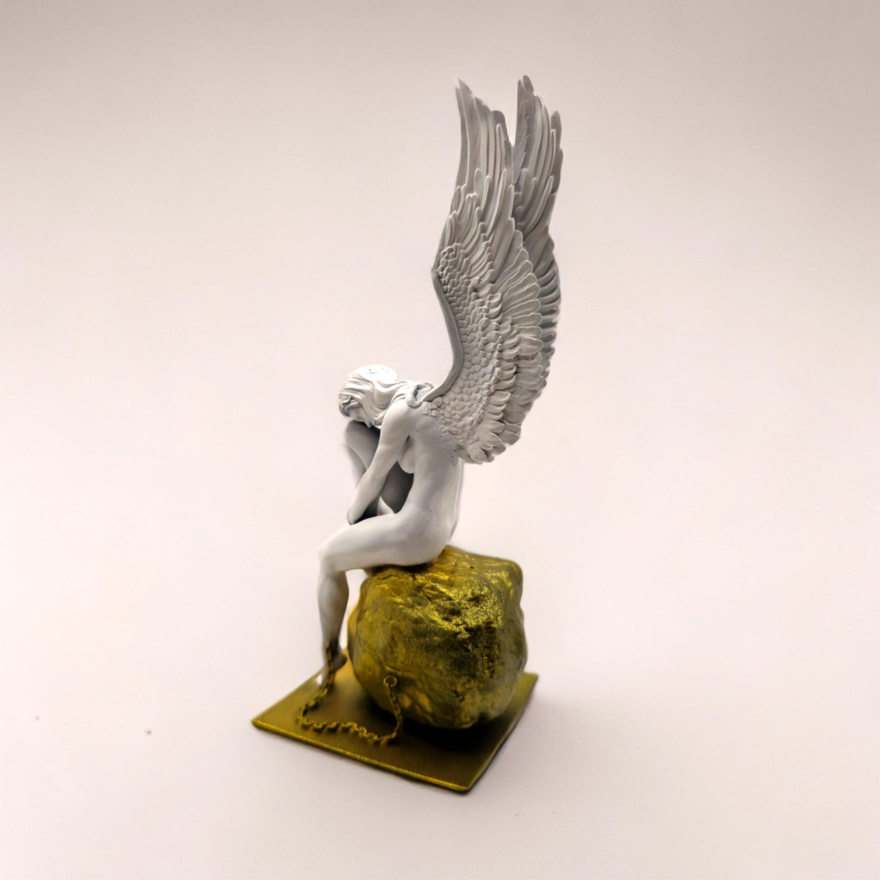 Statue of a chained angel seated on a textured pedestal, with detailed wings and a contemplative pose.